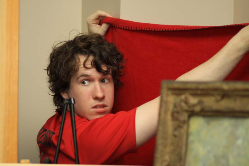 a man holding a red blanket