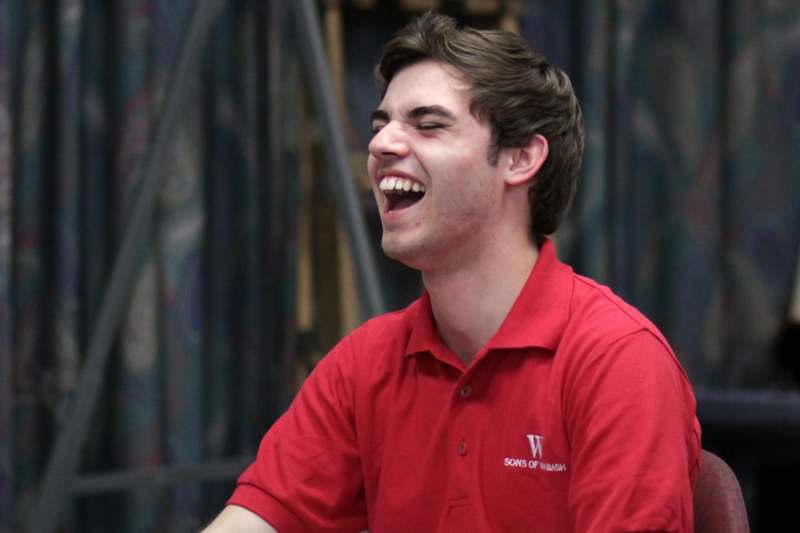 a man in a red shirt laughing