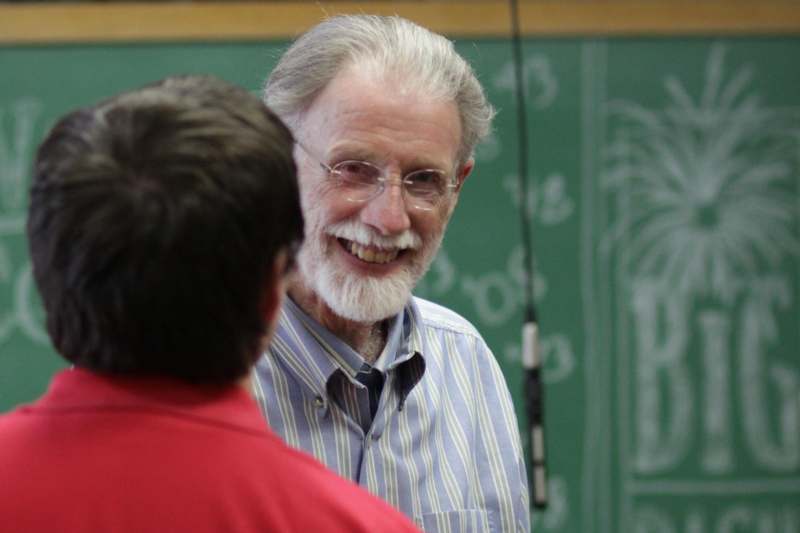 a man with white beard and glasses smiling