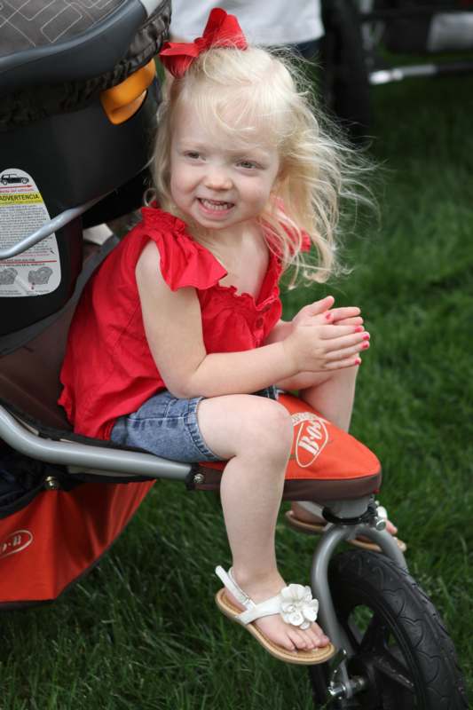 a girl sitting on a stroller