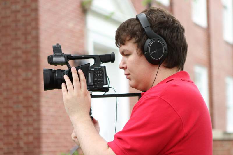 a man wearing headphones and holding a video camera