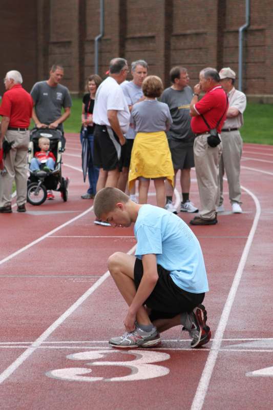 a man tying his shoelaces on a track
