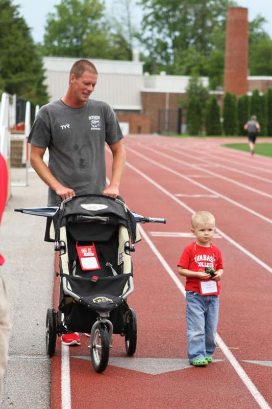 a man pushing a stroller on a track