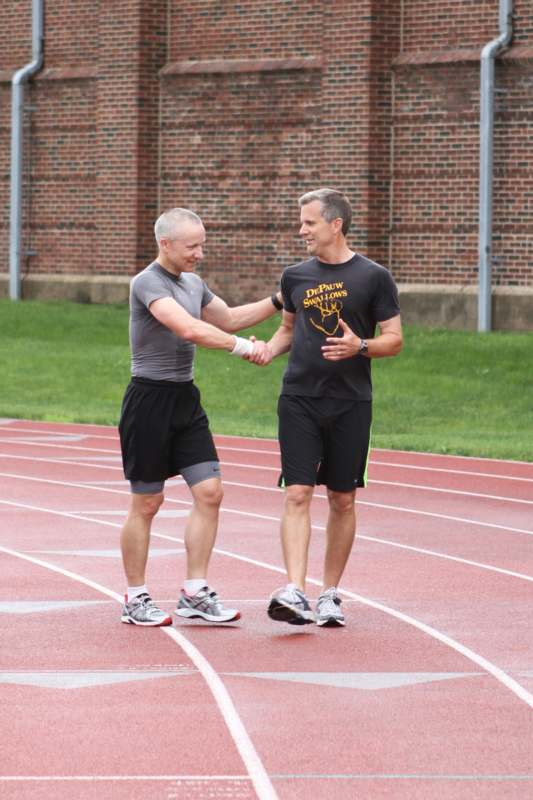two men shaking hands on a track