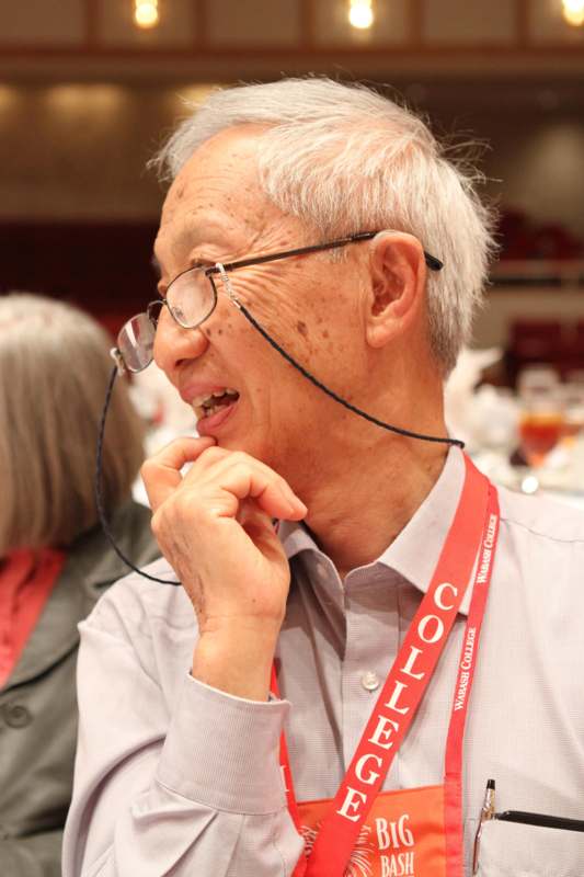 a man wearing glasses and a lanyard