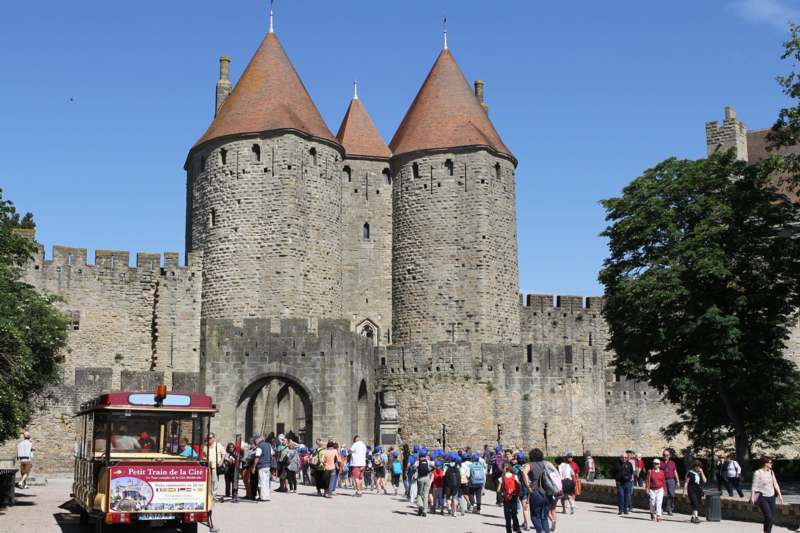 a group of people outside of a castle with Carcassonne in the background