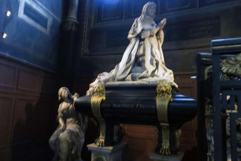 a statue of a woman kneeling on a black pedestal