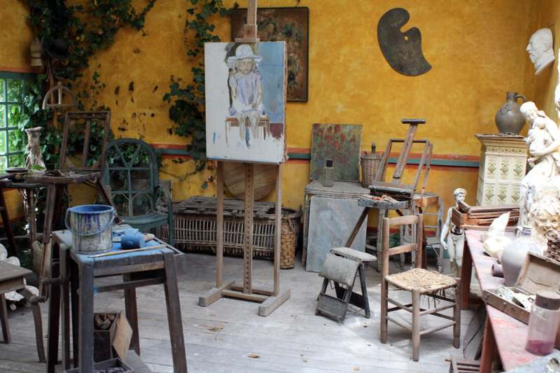 an art studio with an easel and painting