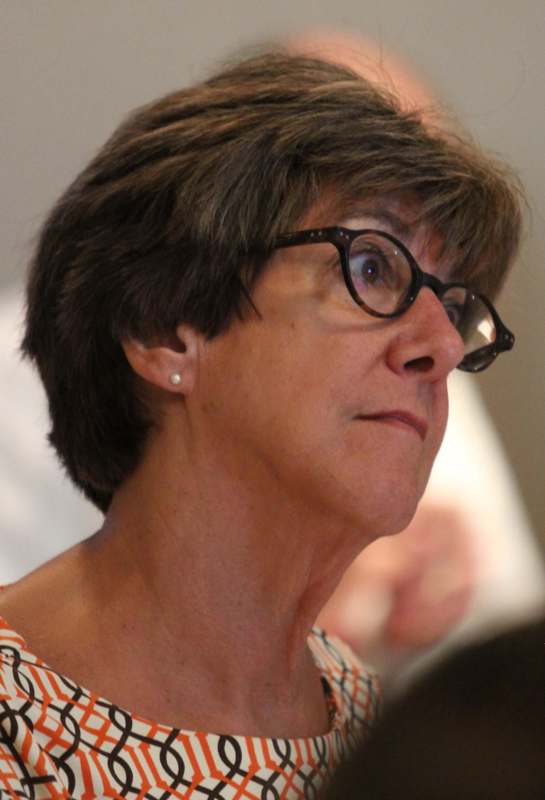 a woman with short brown hair wearing glasses