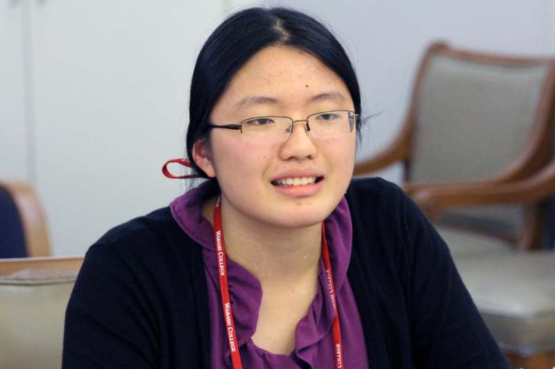a woman wearing glasses and a purple shirt