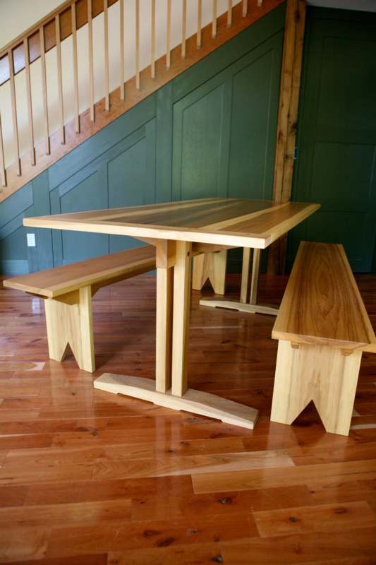 a table with benches on a wood floor