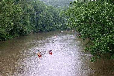 a group of people in canoes in a river