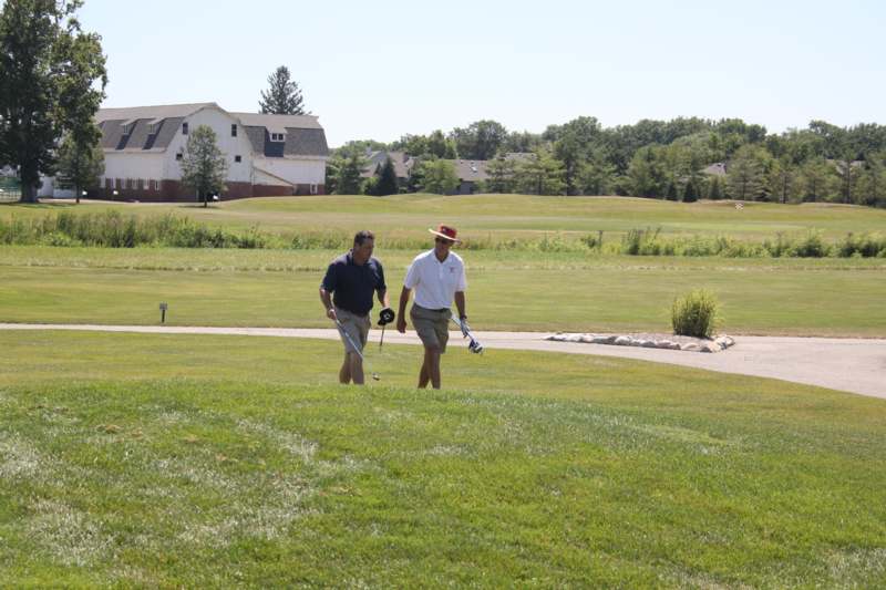 two men walking on a golf course