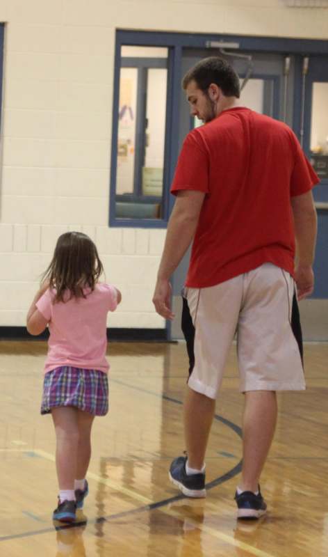 a man and a girl walking in a gym