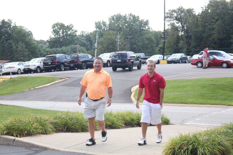 two men walking on a sidewalk
