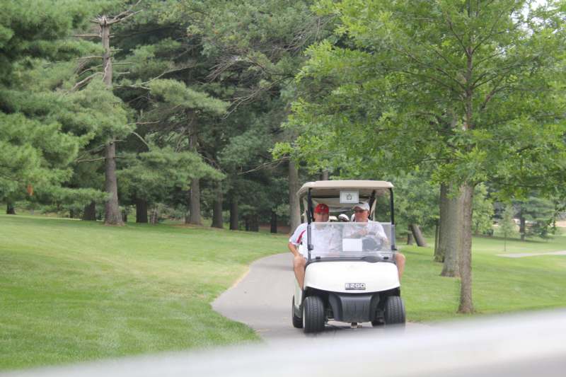 a group of people driving a golf cart
