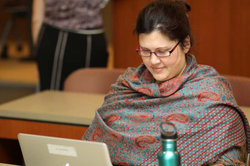 a woman in a scarf looking at a laptop