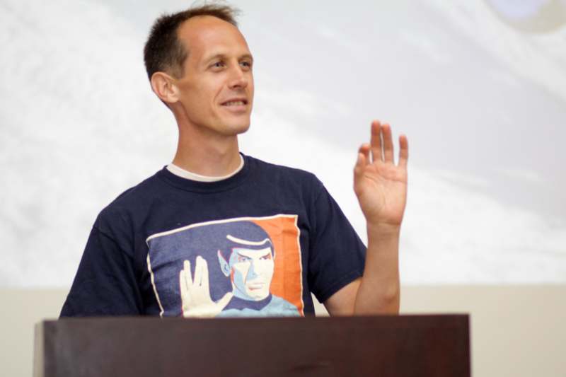 a man standing at a podium raising his hand