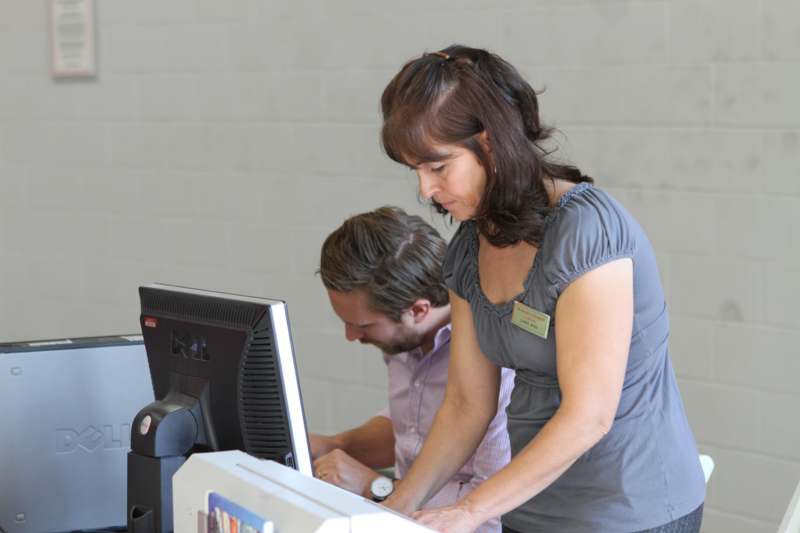 a woman and man working on a computer
