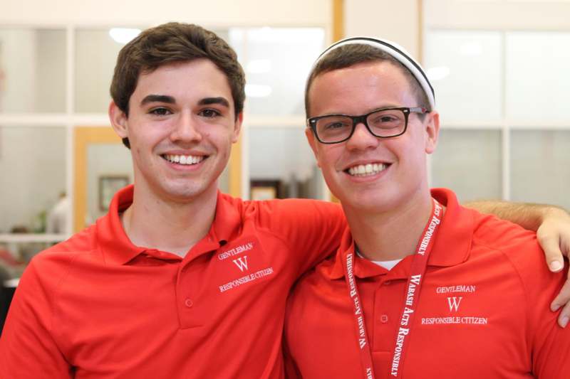 two men wearing red polo shirts