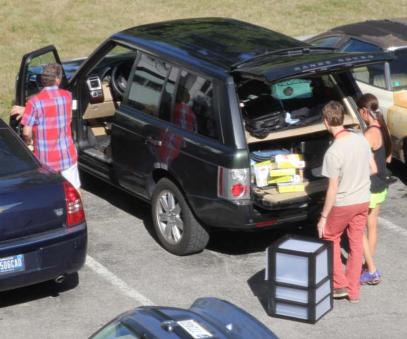 a group of people loading items into a car