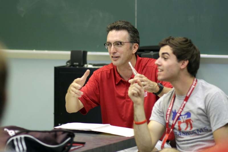 a man in red shirt pointing at another man
