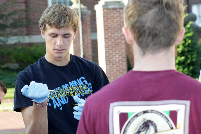 a man wearing gloves and looking at another man