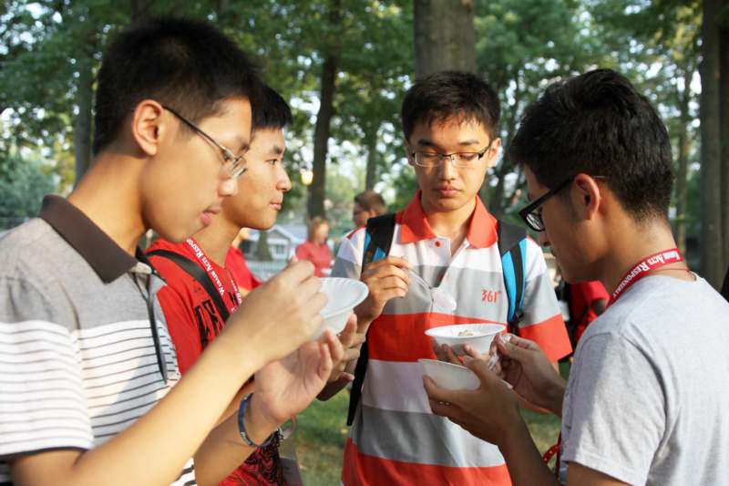 a group of young men eating food outside