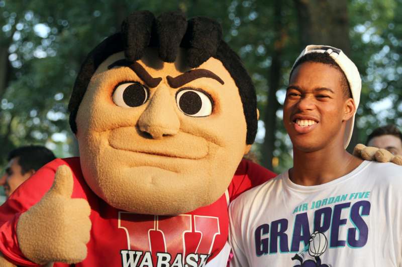 a man posing with a large mascot