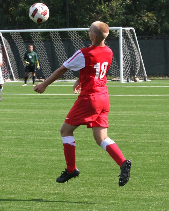 a man in red uniform kicking a ball