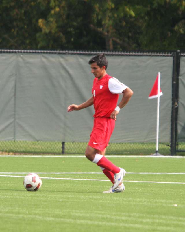 a man in a red uniform kicking a football ball