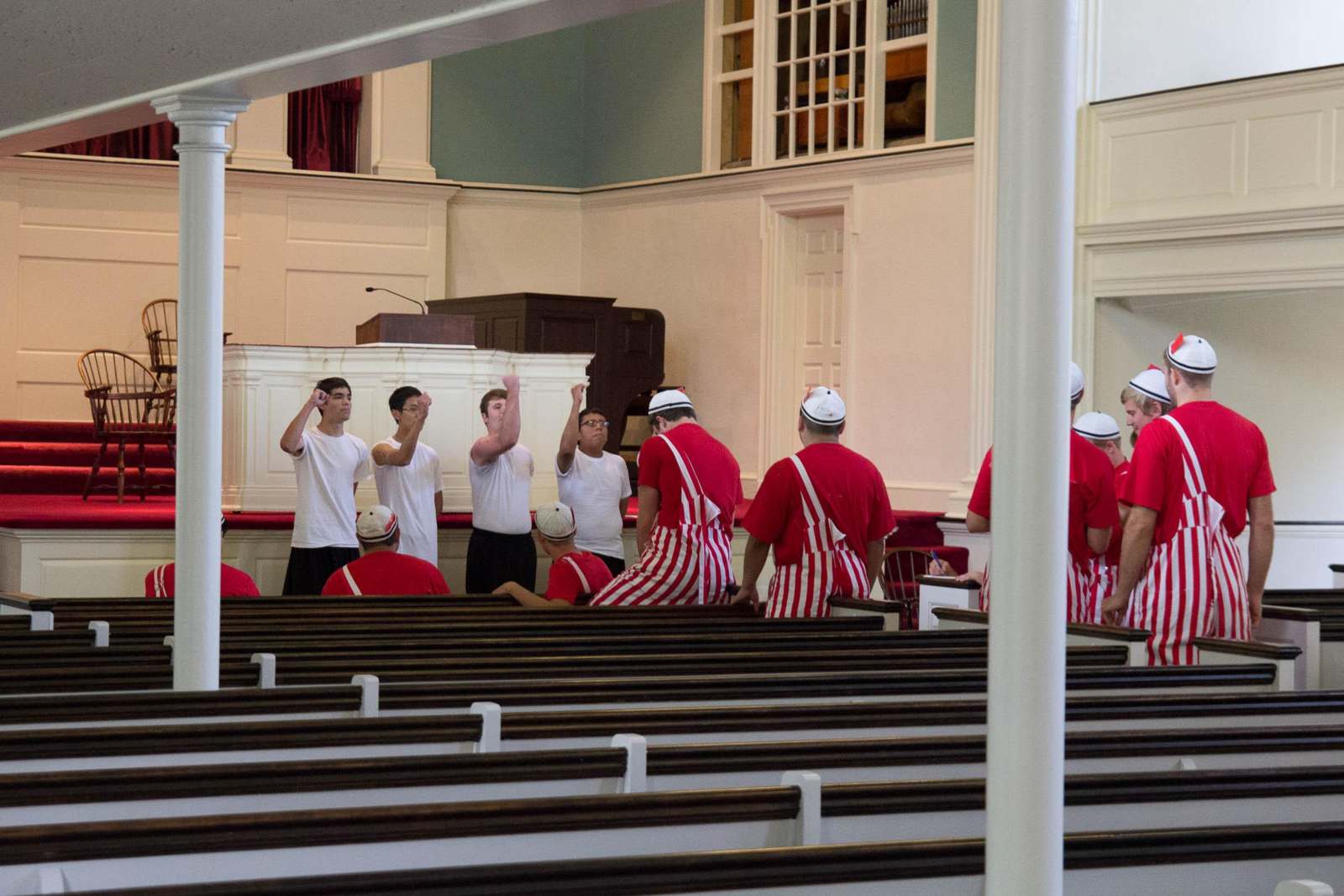 a group of people in red and white striped aprons in a church