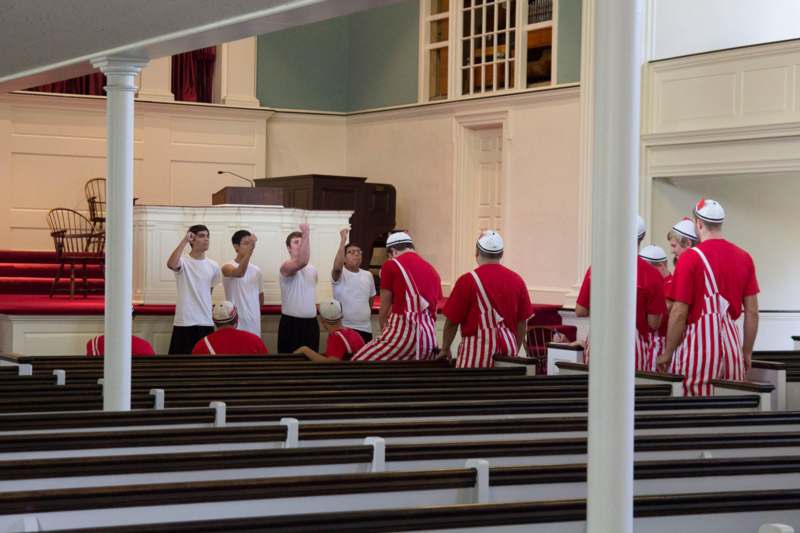a group of people in red and white striped aprons in a church