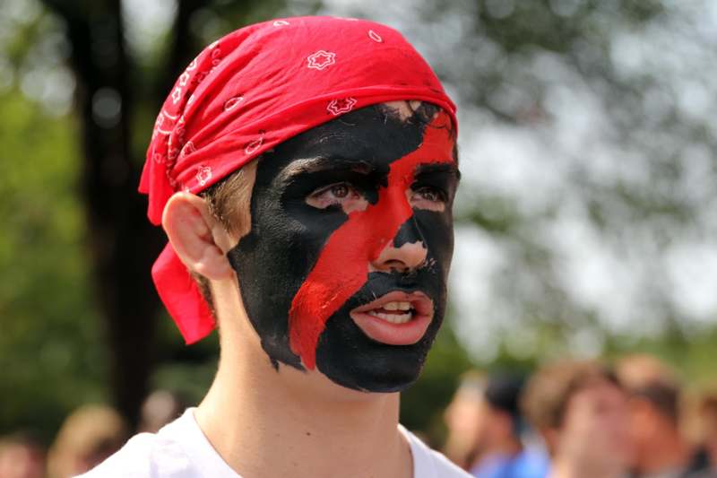 a man with black face paint and red bandana