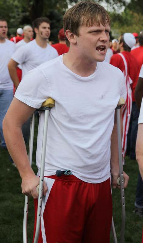 a man with crutches and a white shirt