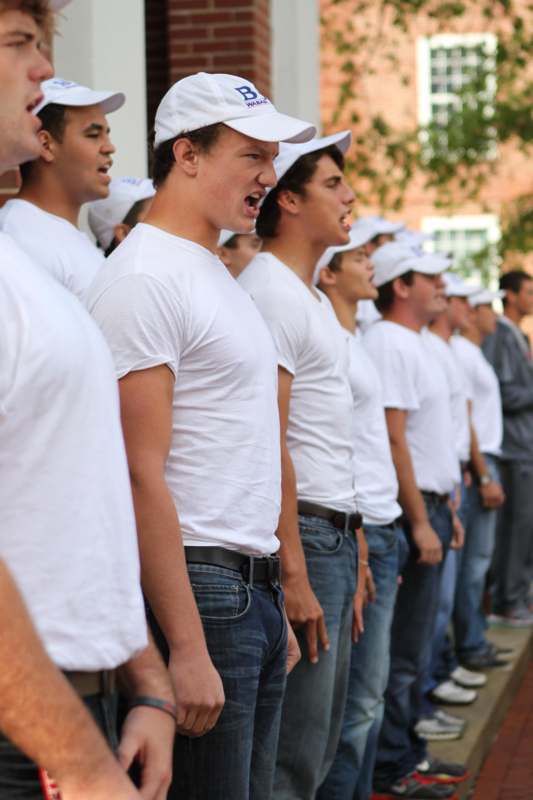 a group of people in white shirts and hats