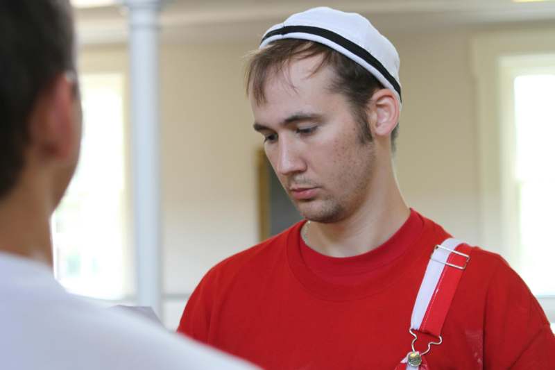 a man in a red shirt and white hat