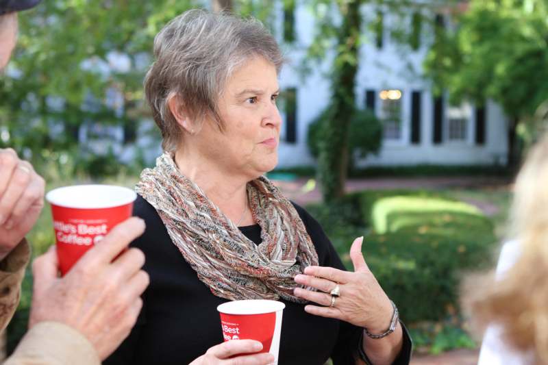 a woman holding cups and talking