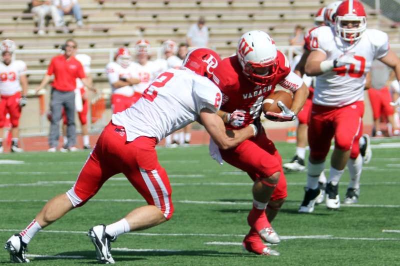 a football player in red uniform running with a football