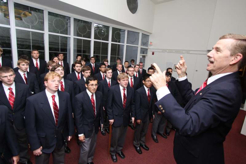 a man in a suit pointing to a group of people