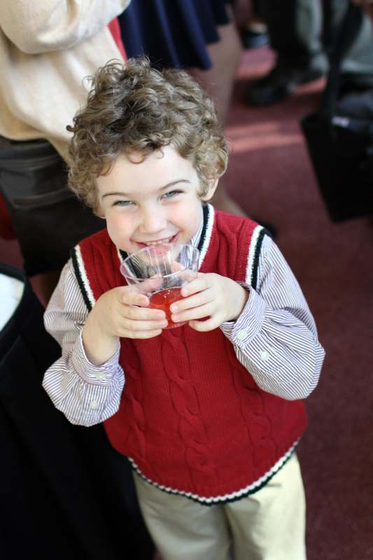 a child holding a glass of juice