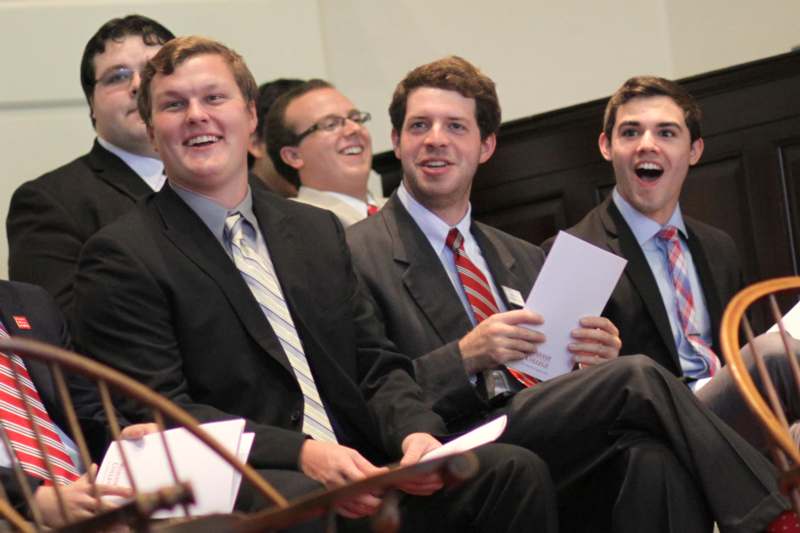 a group of men in suits laughing
