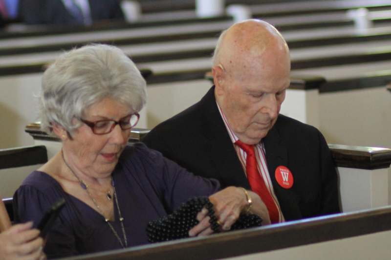 a man and woman sitting in pews