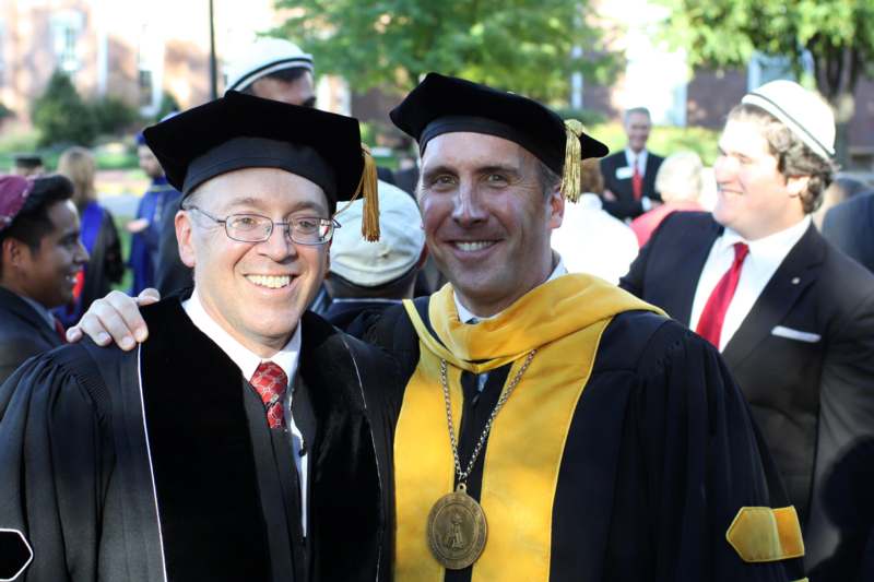 a man in graduation gowns and cap and gowns
