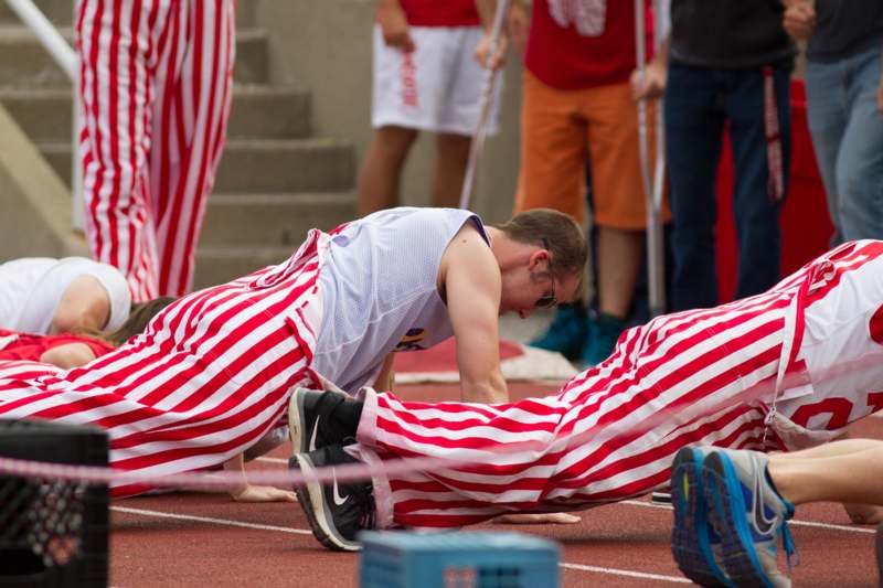 a man in striped pants doing push ups on a track