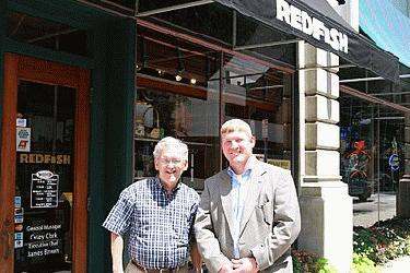 a couple of men standing in front of a store