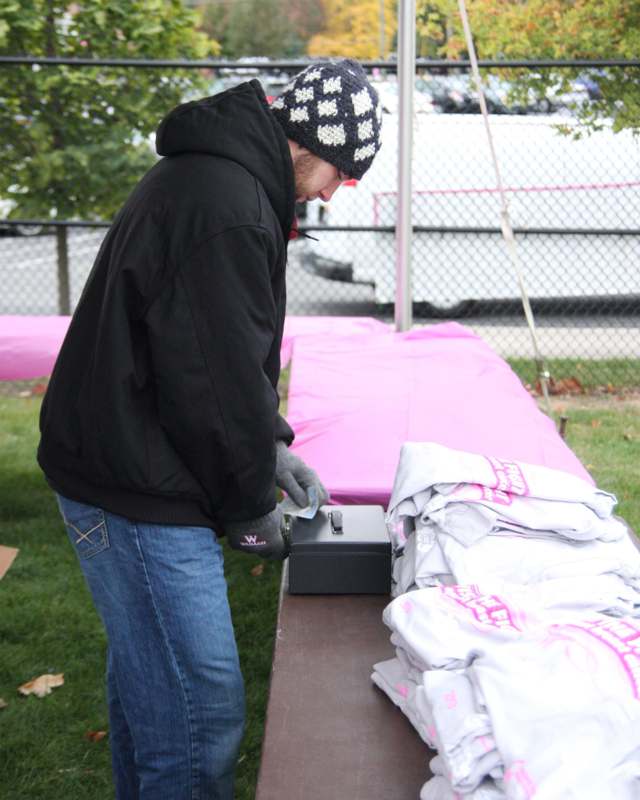 a man standing outside by a box with a metal box with a pink cover