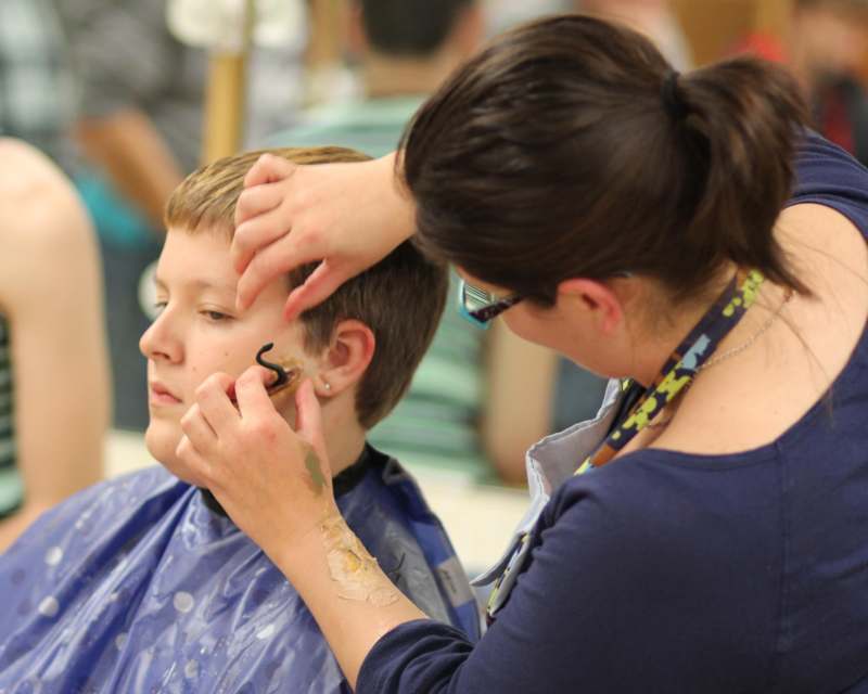 a woman cutting a boy's hair