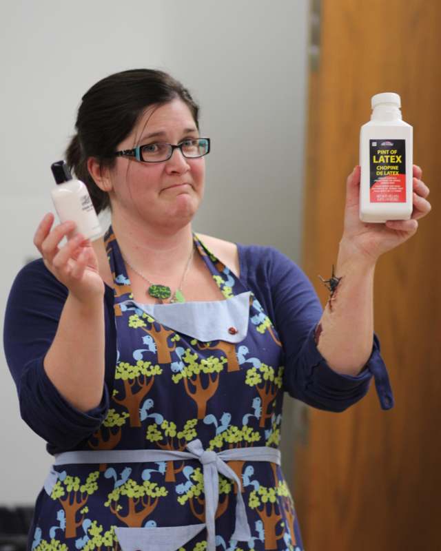 a woman holding a bottle of latex