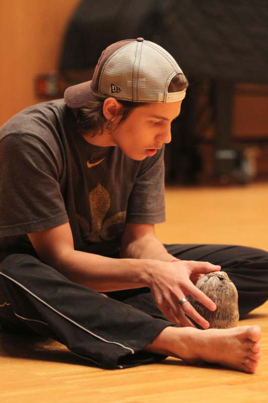 a man sitting on the floor holding a coconut